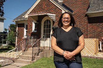 Woman smiling while standing in front of home