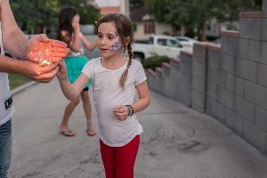 Dad helping daughter light a sparkler