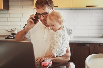 Man on phone holding his daughter