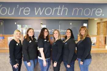 Six women standing in front of sign