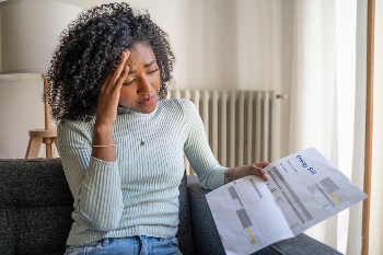 Woman upset holding energy bill