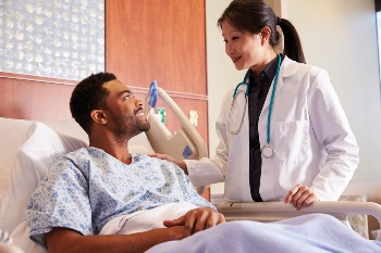 Man in hospital bed with woman doctor