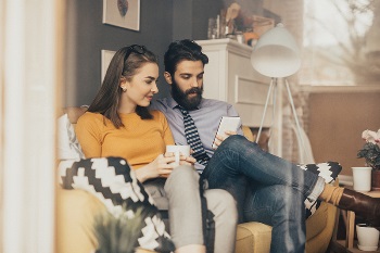 millennial couple reading money articles on phone