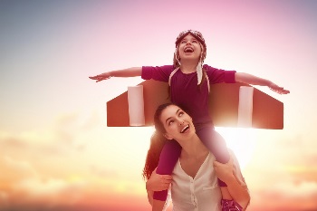 Son with airplane wings on mom's shoulders