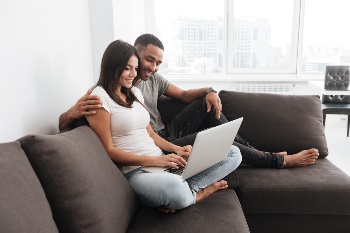 Couple looking at laptop on couch